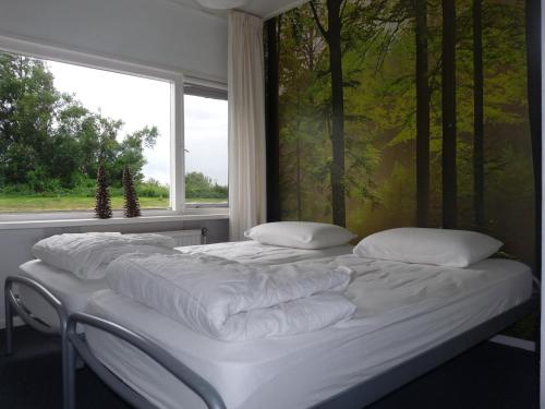 two white beds in a room with a window at Woonboot de Waterwoning in Irnsum
