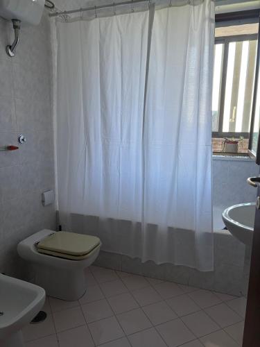 a bathroom with a toilet and a shower curtain at Sea & spiagge a 200m Stella del Salento in Brindisi