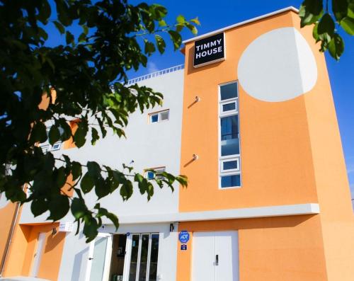 an orange and white building with a sign on it at Yang Yang Timi House Pension in Yangyang