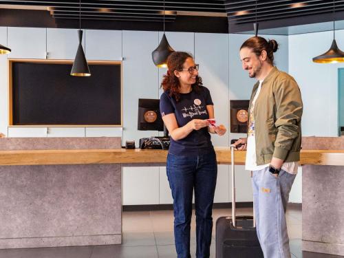 a man and a woman standing in a kitchen at Ibis Brussels City Centre in Brussels