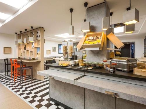 a large kitchen with a counter in a restaurant at ibis Bordeaux Centre - Gare Saint-Jean in Bordeaux