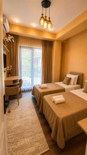 a hotel room with two beds and a desk at Sheki Secret Garden Boutique Hotel & Guest House in Sheki