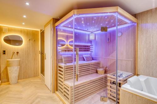 a bathroom with a shower with purple lighting at Studios - Appartements Le Médicis in Rouen