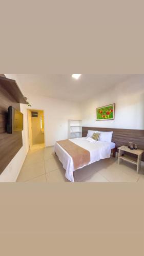a large bedroom with a bed and a tv at Pousada Do Joe in Morro de São Paulo