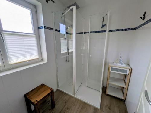 a bathroom with a shower and a wooden stool at Haus Wikinger in Born