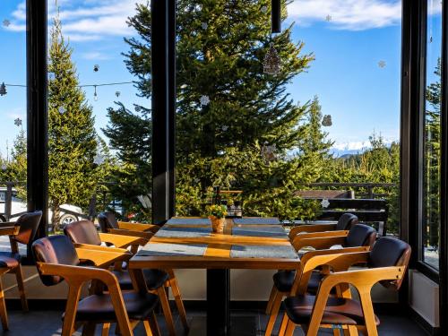 a dining room with a table and chairs and a large window at Pensiune & Restaurant Victoria in Păltiniş