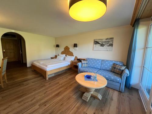 a living room with a couch and a bed and a table at Hotel Alpengasthof Löwen in Bad Hindelang