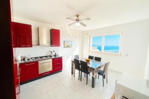 a kitchen with red cabinets and a table with chairs at DreamLiving Vasto Panorama in Vasto