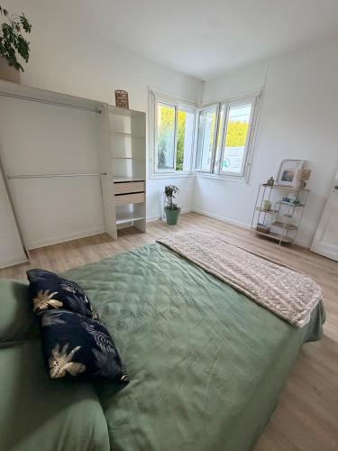 a bedroom with a large green bed in a room at logement tranquille avec jardin in Saint-Germain-et-Mons