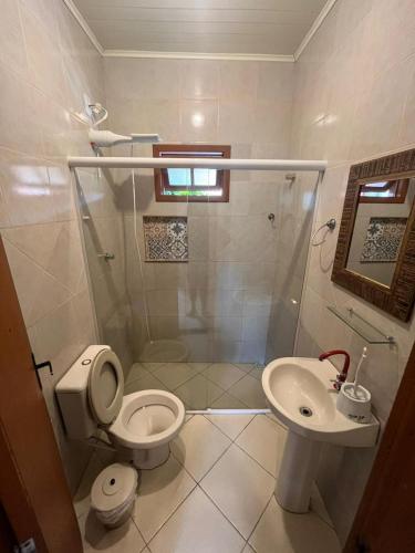 ein Badezimmer mit Dusche, Toilette und Waschbecken in der Unterkunft Pousada Chaday in Imbituba
