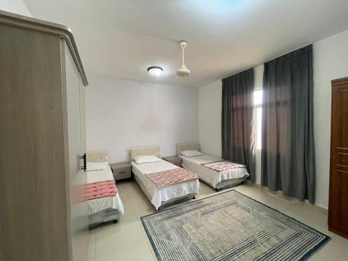a room with two beds and a window at Adheeiz beach in Salalah