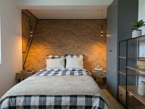 a bedroom with a bed with a wooden headboard at Skośne Domki 2 in Chmielno