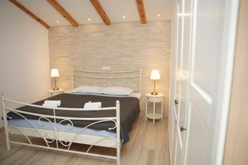 a bedroom with a bed and a brick wall at Apartments & Villa Tisno in Obrovac
