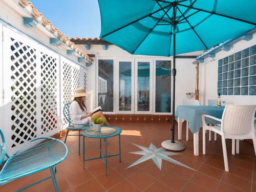 a woman sitting on a porch reading a book at Sweet home Santa Lucia in Santa Lucia