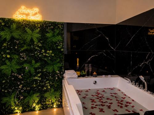 a bathroom with a bath tub and a green wall at Seven Suite SPA in Fiumicino