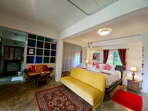 a bedroom with a large bed and a desk at Nan De Panna Homestay in Nan
