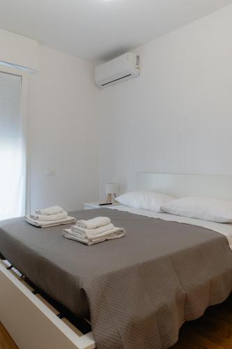 a white room with a bed with towels on it at Mara's home in San Salvo