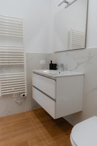 a white bathroom with a sink and a mirror at Mara's home in San Salvo