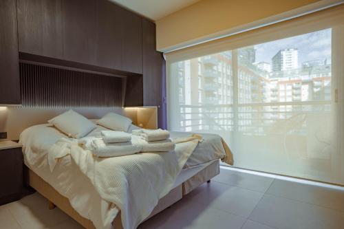 a bedroom with a bed and a large window at Elegante estudio in Buenos Aires