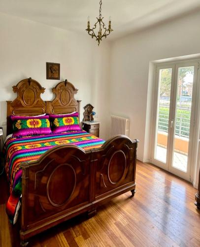 a bedroom with a wooden bed with a wooden floor at Domus Dafne Apartment in Senigallia