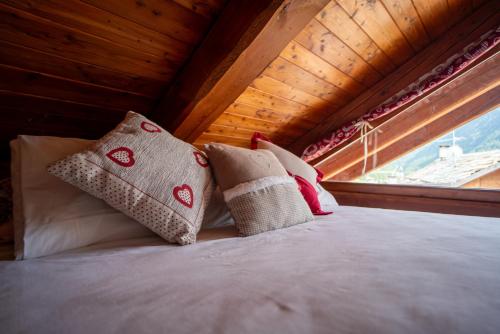 a bed with pillows in a room with a window at Casa Lotre in Pragelato