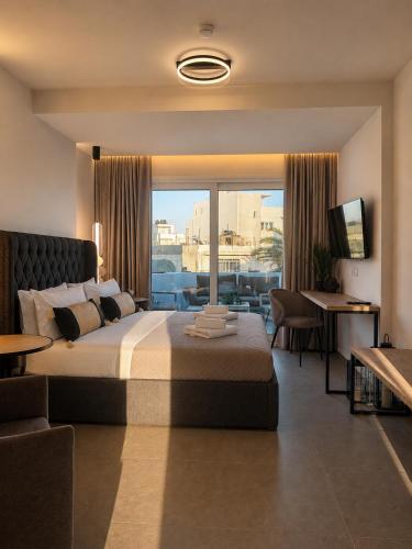 a hotel room with a bed and a large window at Cabana Condo in Ierapetra