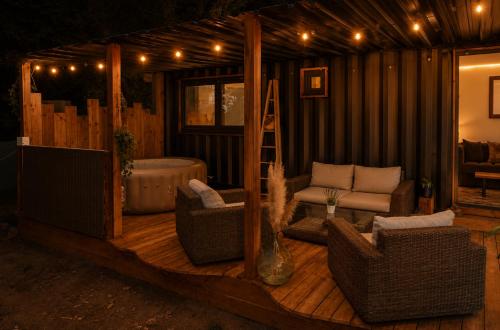 a living room with a deck with chairs and a tub at Ô Temps Des Pins in Éguilles