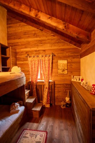 a room with two bunk beds and a window at Casa Lotre in Pragelato