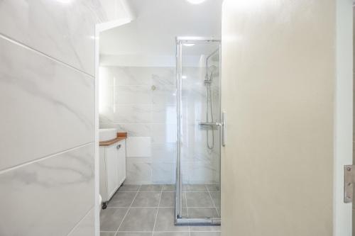 a shower with a glass door in a bathroom at Casa da Floresta in Machico