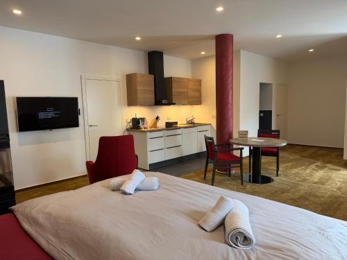 a bedroom with a large bed and a kitchen at PAULINEN Residenz Komfortabel wohnen - Flexibel ankommen in Detmold