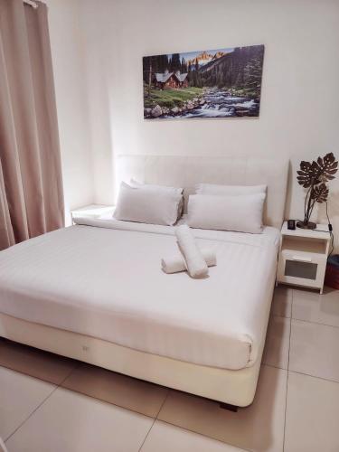 a bedroom with two beds and a painting on the wall at Swiss Garden resort residence by Moonlight in Kuantan