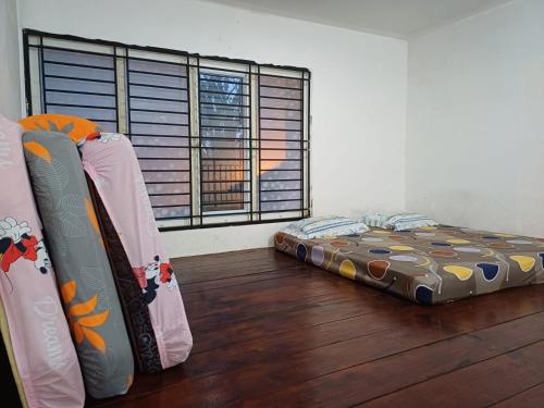 a bedroom with two beds and a large window at Villa GreenHill A1 SibolangitView in Bandarbaru