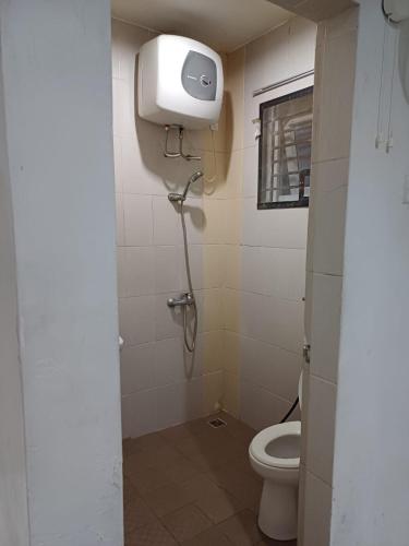 a bathroom with a toilet and a paper dispenser on the wall at Villa GreenHill A1 SibolangitView in Bandarbaru