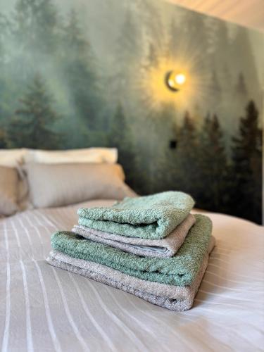 a pile of towels sitting on top of a bed at La Loge des Deux Sapins in Oberbetschdorf