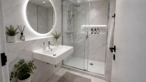 a white bathroom with a sink and a shower at Apartment in Žatec in Žatec