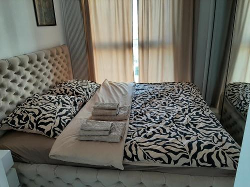 a bed with black and white sheets and towels at ApartamentyDiana in Pogórze
