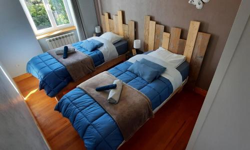 a bedroom with two beds and a large headboard at Gite au Petit Verger in Masevaux