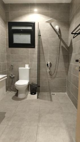 a bathroom with a shower and a toilet in it at Lurret Hotel in Qaryat at Ta‘mīr as Siyāḩīyah