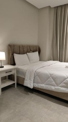 a bedroom with a bed with a nightstand and a white bed sidx sidx sidx at Lurret Hotel in Qaryat at Ta‘mīr as Siyāḩīyah