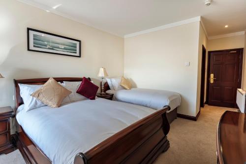 a hotel room with two beds and a table at Chester Beatty Inn in Ashford