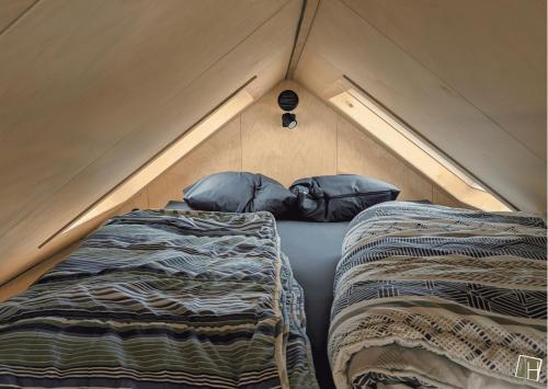 a bedroom with two beds in a tent at Camping Houtum in Kasterlee