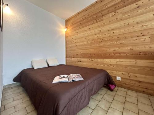 a bedroom with a bed with a wooden wall at Studio cosy 2/3 pers au cœur de Briançon, proche centre-ville et télécabine - FR-1-330C-42 in Briançon