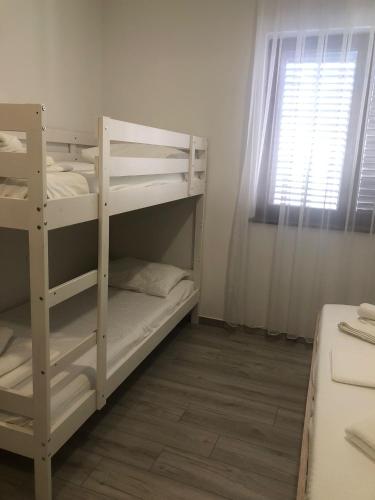 a room with two bunk beds and a window at FIORE Seaview Rooms - Premium Location in Selce