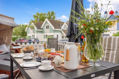 a table with food and a vase of flowers at Strandhaus Bernstein in Breege in Breege