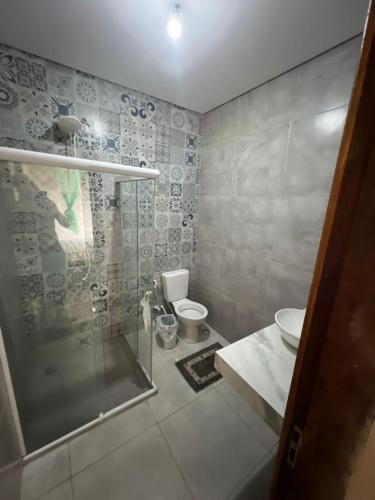 ein Badezimmer mit Dusche, Toilette und Waschbecken in der Unterkunft Jeribucatu in Itacaré