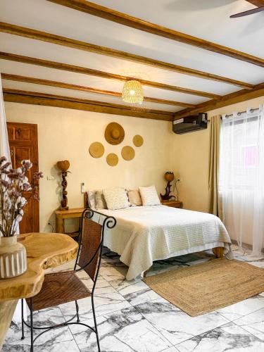 a bedroom with a bed and a table and chairs at Hotel Boutique Casa Mambo in Cahuita