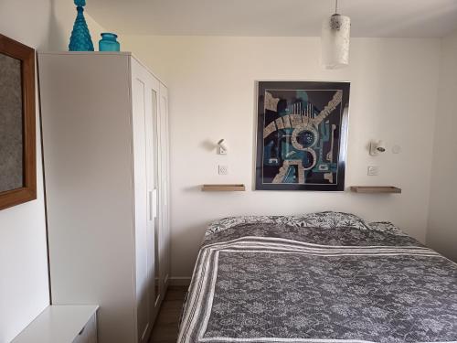 a bedroom with a bed and a picture on the wall at maisonnette entre bois et champs in Crest