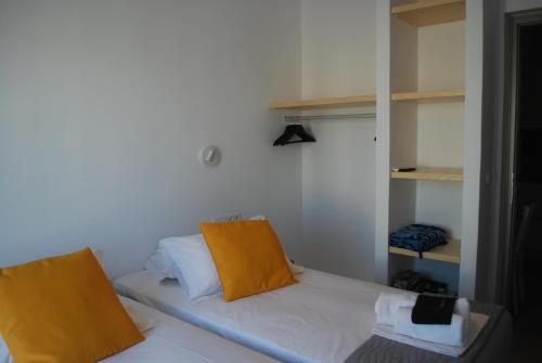 a small room with a bed with yellow pillows at Busho Residence 2 in Naousa