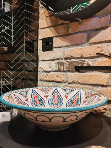 a large bowl sitting on a table next to a brick wall at Casa FaRa in Vama Veche