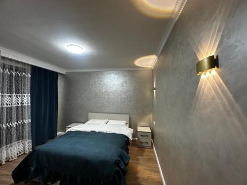 a bedroom with a large bed with a blue blanket at Guest house 97 in Karakol